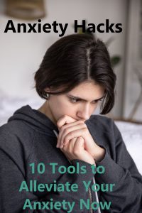Woman in gray hoody, with hair pulled back into a loose ponytail looks down with her hands folded into each other and her mouth resting on the top of her left hand. Black and Teal text reads ANXIETY HACKS 10 Tools to Alleviate Your Anxiety Now