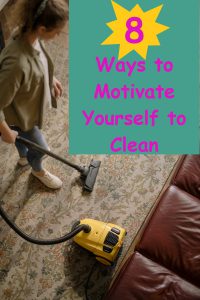 woman with hair tied back in ponytail standing on carpet with vacuum in hand. Vacuuming carpet with brown couch in front of vacuum. 8 Ways to motivate yourself to clean